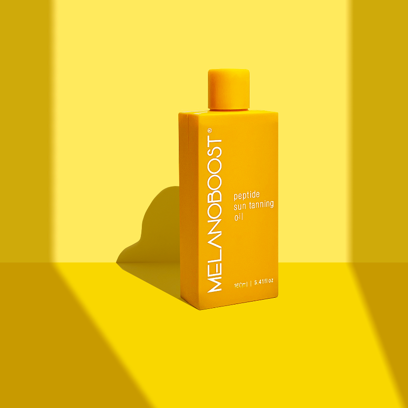 yellow_bottle_of_Melanoboost_Peptide_Sun_Tan_Accelerator_Oil_against_yellow_background